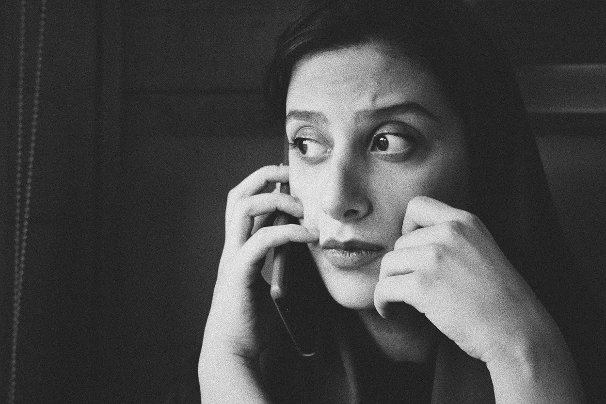 grayscale photo of a woman holding a smartphone